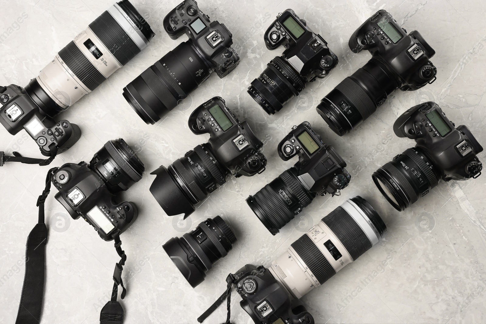 Photo of Modern cameras on gray marble table, flat lay