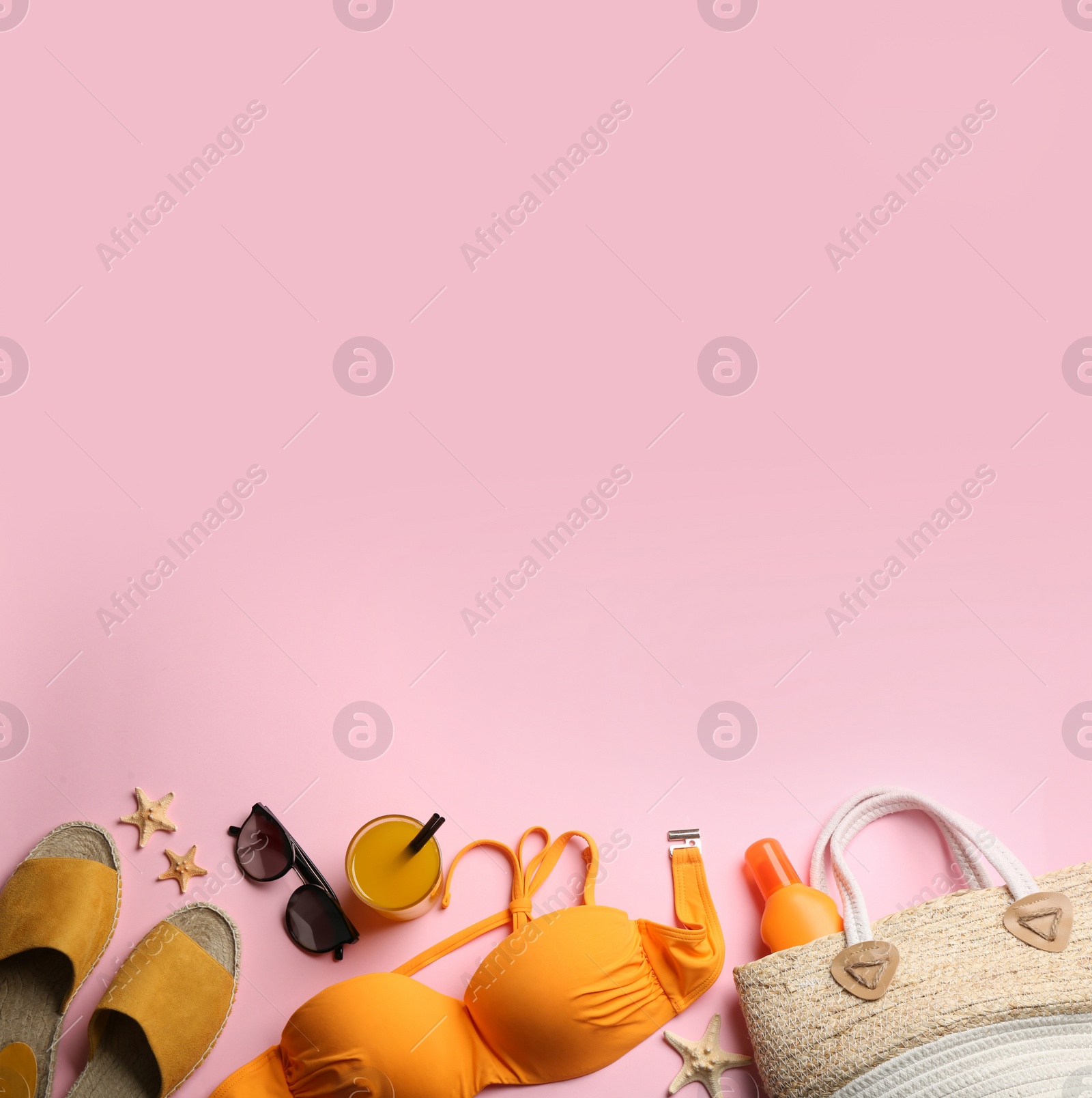 Photo of Beach accessories on pink background, flat lay. Space for text