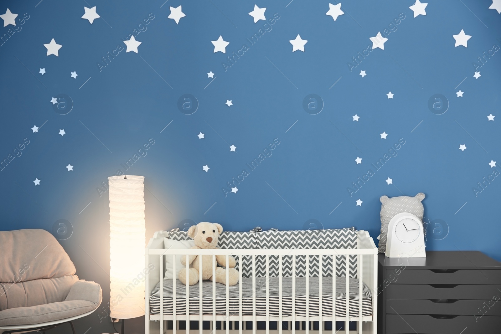 Photo of Baby room interior with comfortable crib and armchair