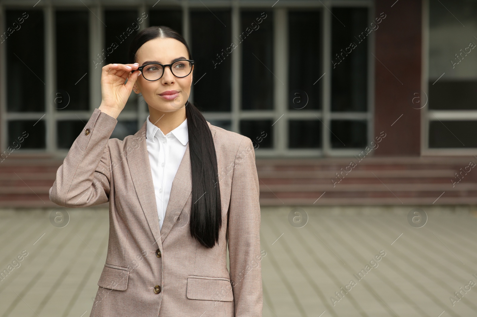 Photo of Beautiful real estate agent in nice suit outdoors, space for text
