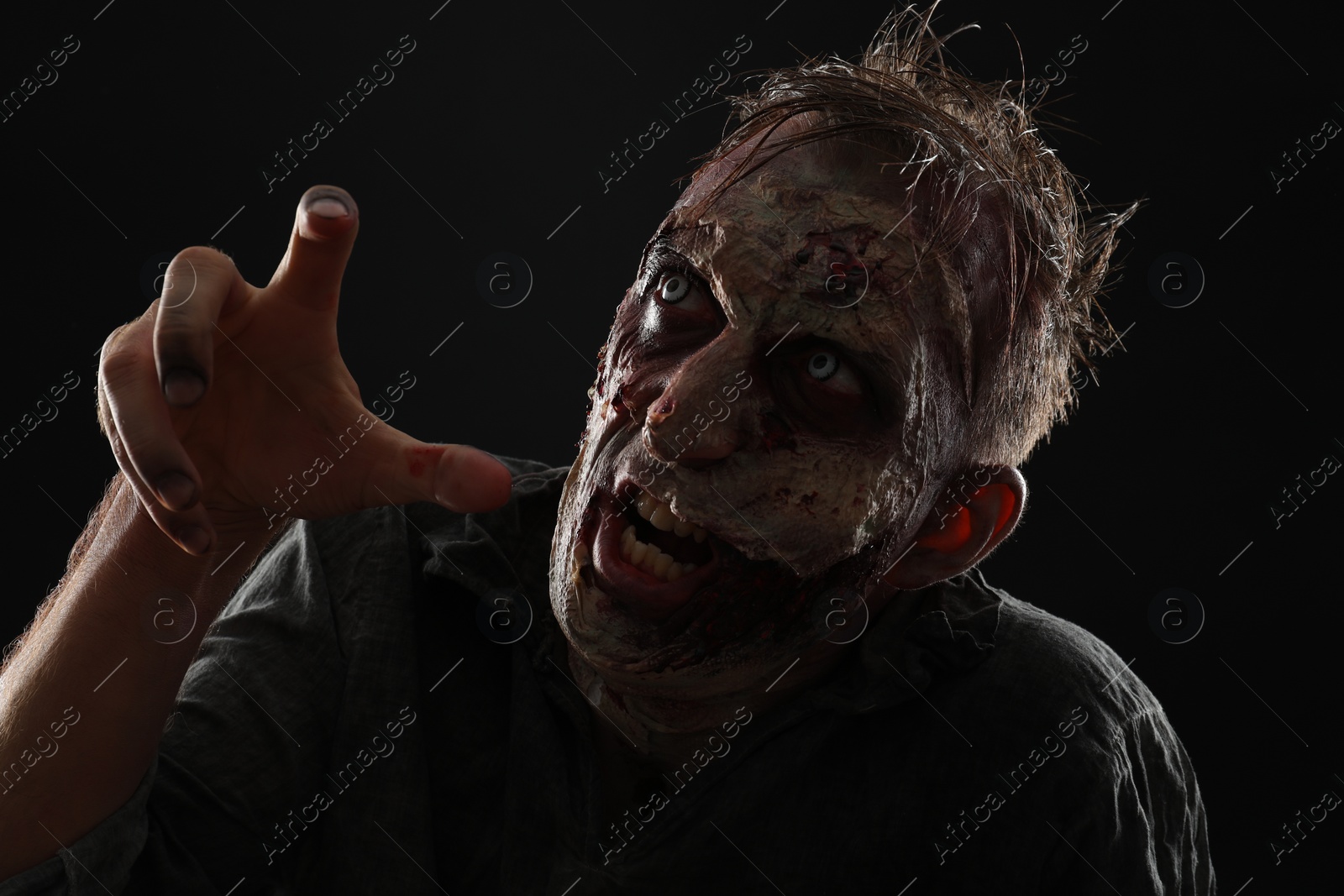 Photo of Scary zombie on dark background. Halloween monster