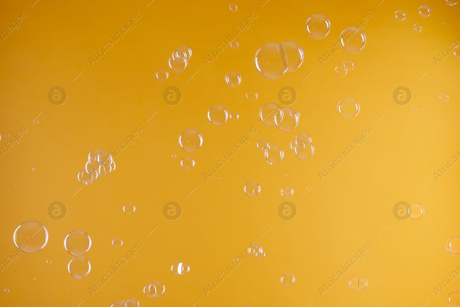 Photo of Many beautiful soap bubbles on orange background