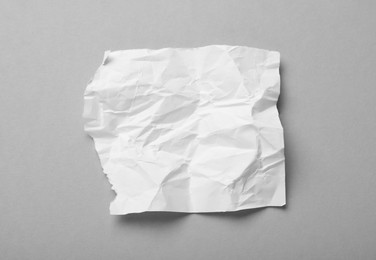 Photo of Sheet of white crumpled paper on grey background, top view