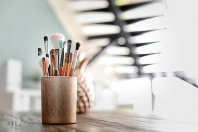 Photo of Holder with makeup brushes on table