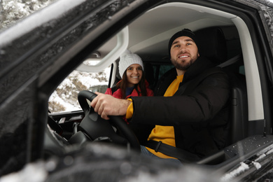 Photo of Young couple traveling by car, view through window. Winter vacation