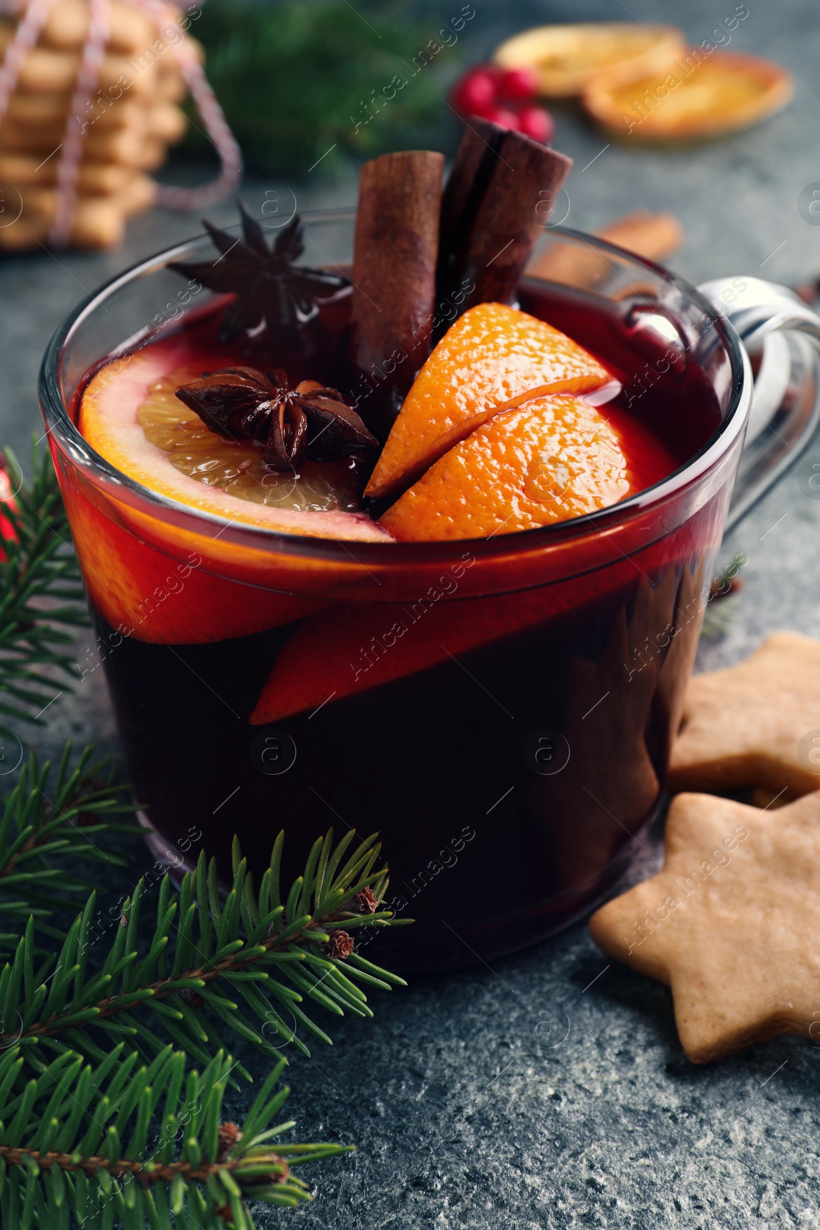 Photo of Aromatic mulled wine, cookies and Christmas decorations on grey table, closeup