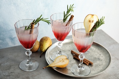 Tasty refreshing pear cocktail with rosemary on table