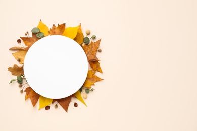 Flat lay composition with autumn leaves and blank card on light background, space for text