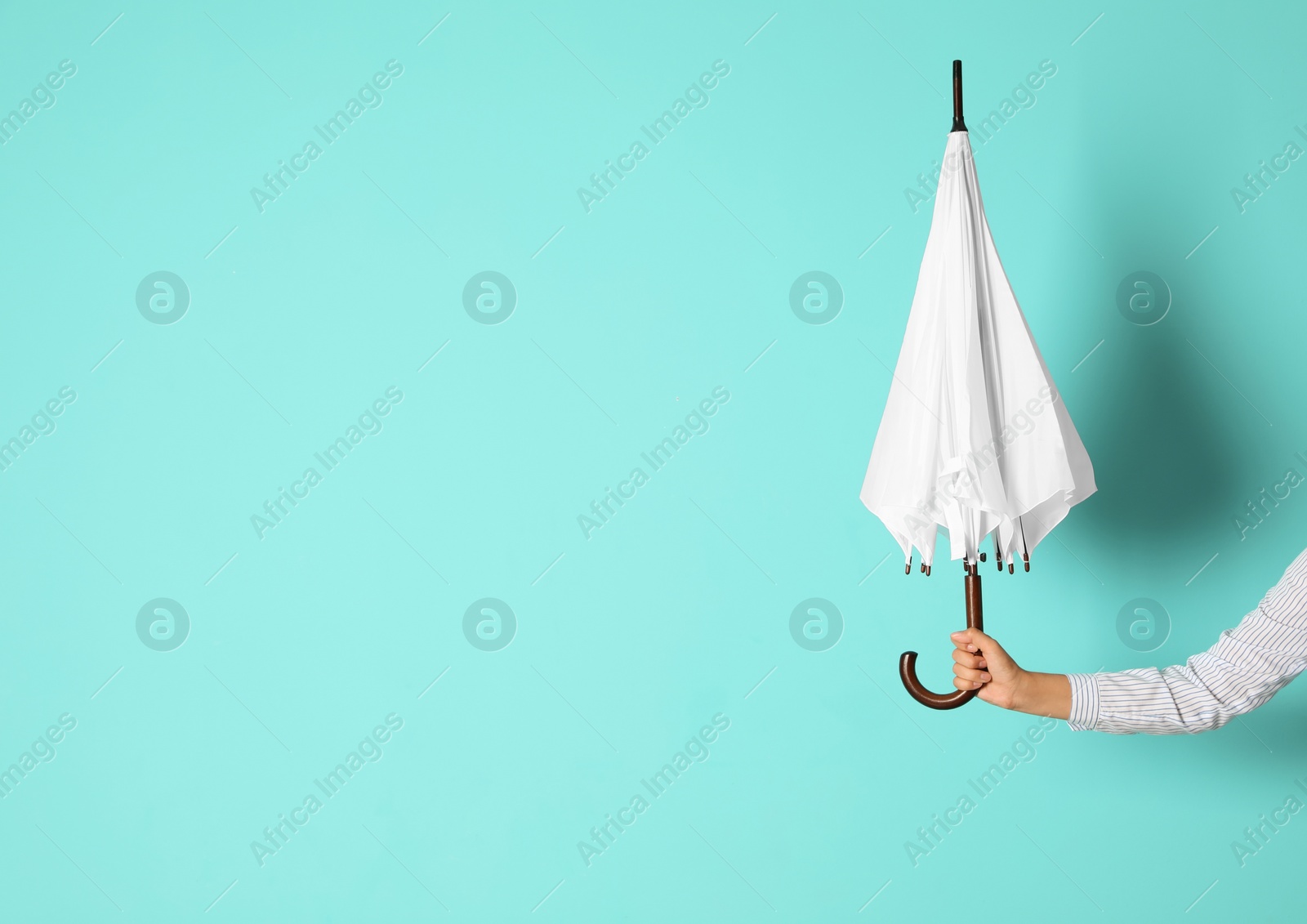 Photo of Woman holding beautiful umbrella on color background with space for design