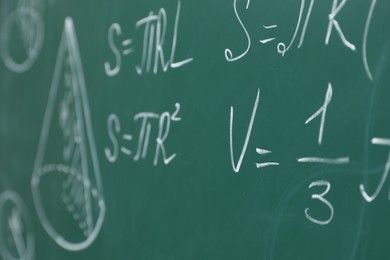 Photo of Different math formulas written with chalk on green board