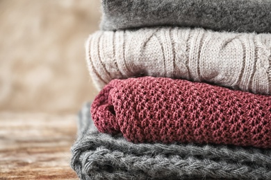 Photo of Stack of warm knitted clothes on grey background