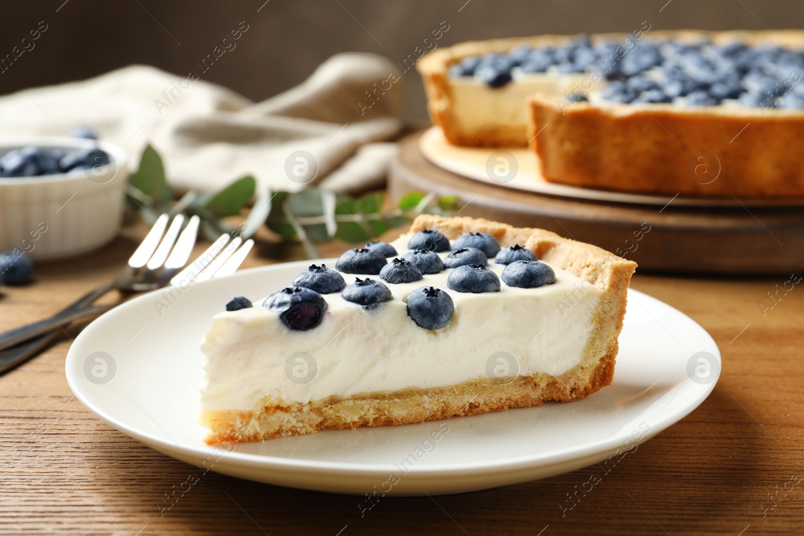 Photo of Plate with tasty blueberry cake on wooden table