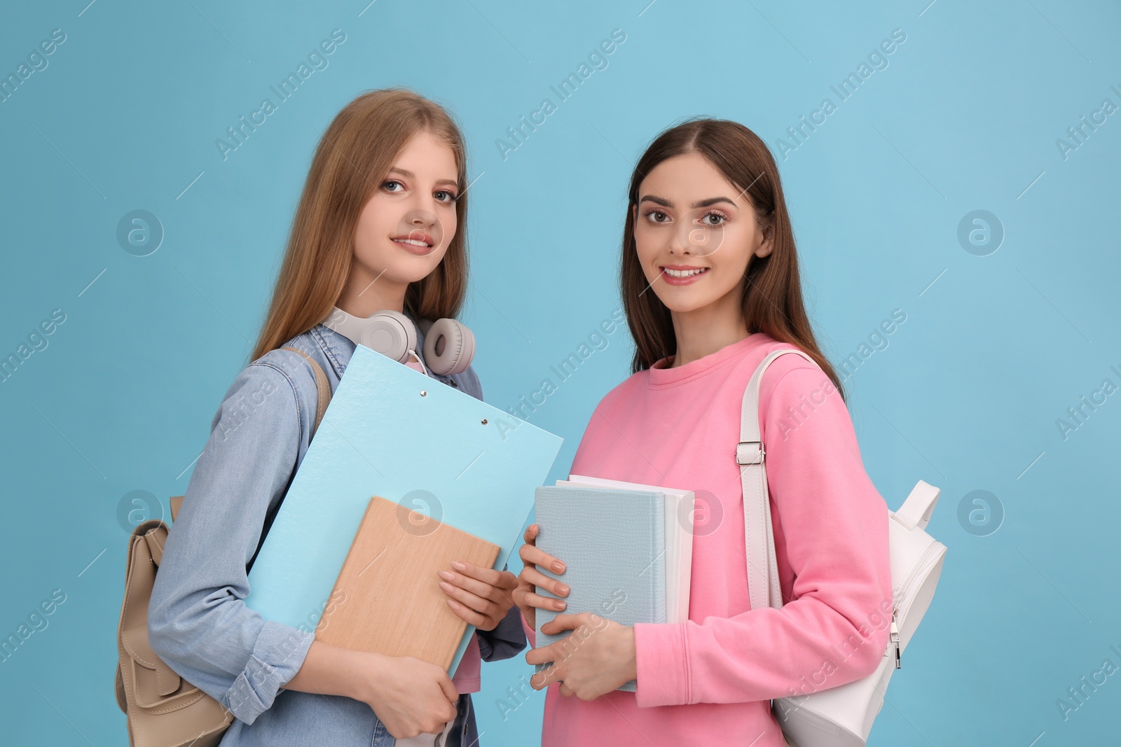 Photo of Teenage students with stationery and backpacks on turquoise background