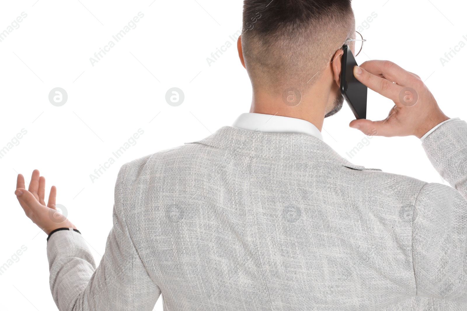 Photo of Businessman talking on mobile phone against white background, closeup