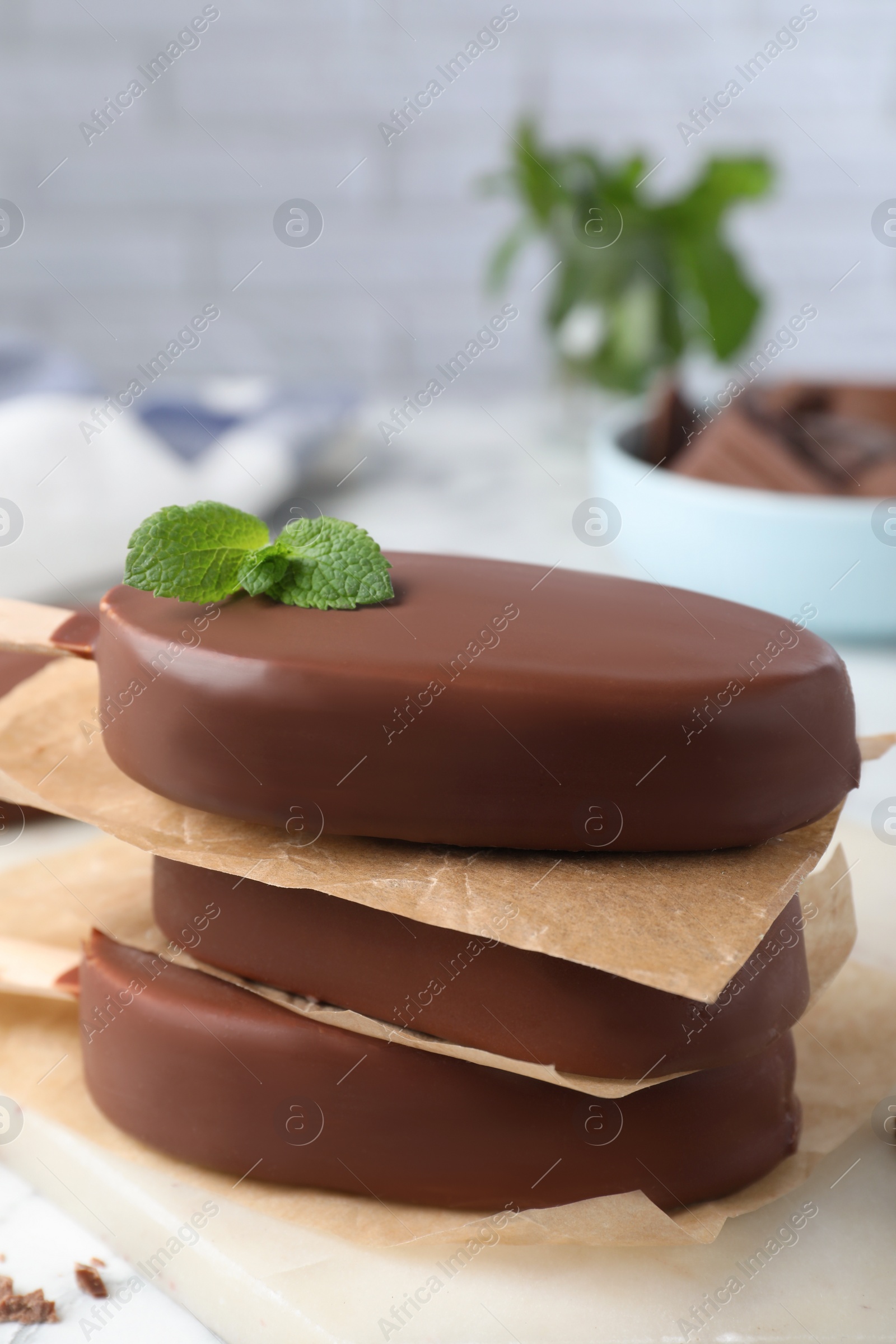Photo of Delicious glazed ice cream bars with mint on board, closeup