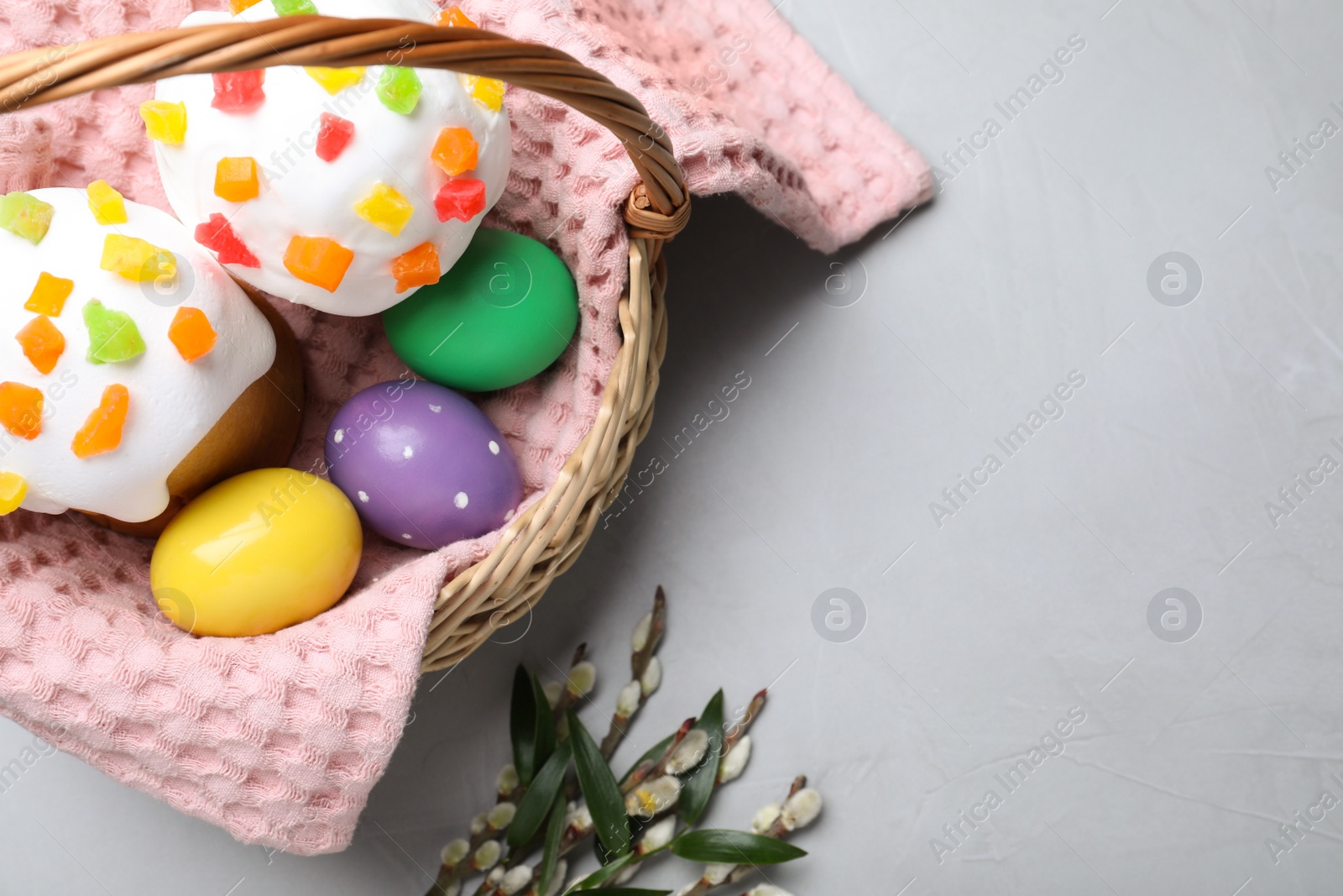 Photo of Easter cakes and painted eggs on light grey table, flat lay