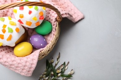 Photo of Easter cakes and painted eggs on light grey table, flat lay