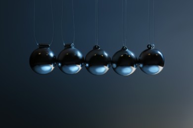 Newton's cradle on grey background, closeup. Physics law of energy conservation