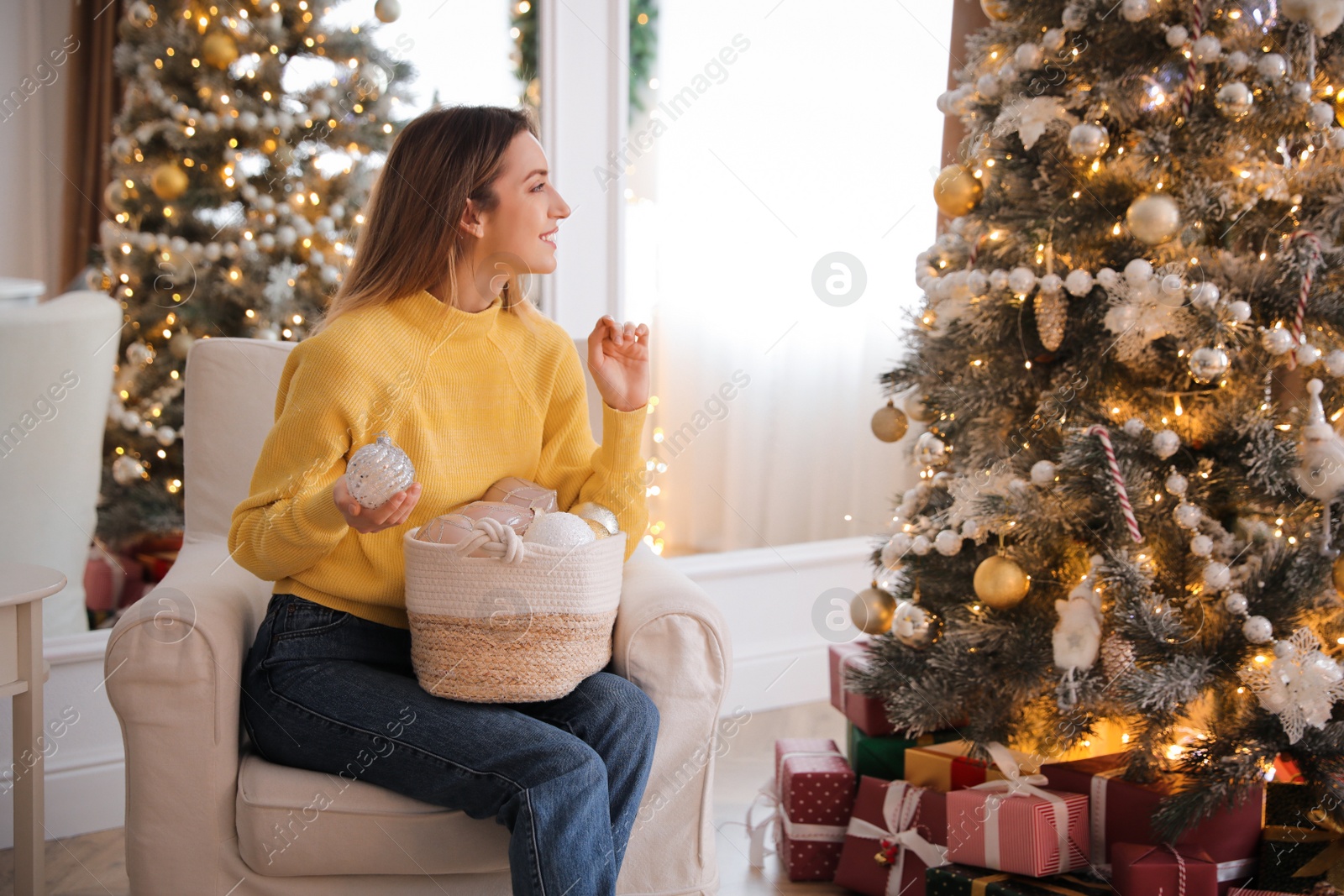 Photo of Beautiful woman decorating Christmas tree at home