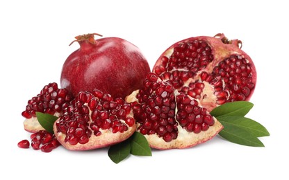 Photo of Ripe pomegranates with green leaves on white background