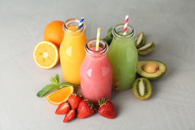 Bottles with tasty juices and ingredients on table