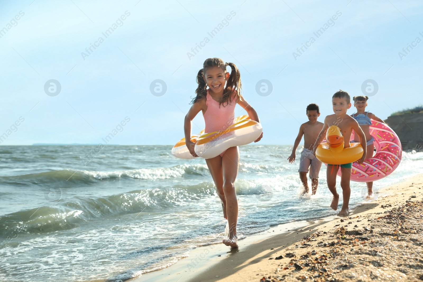 Photo of Cute children enjoying sunny day at beach. Summer camp