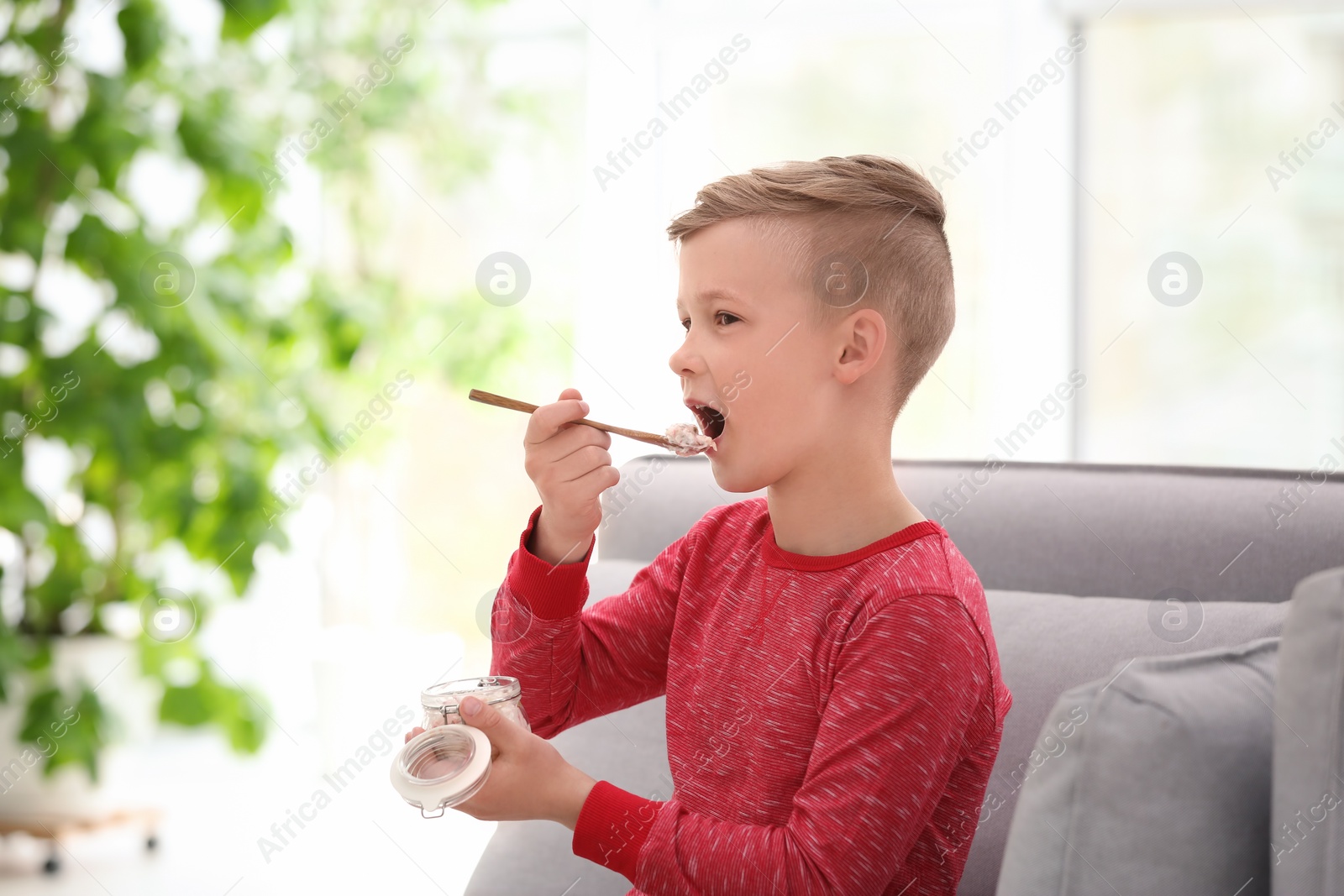 Photo of Little boy with yogurt indoors