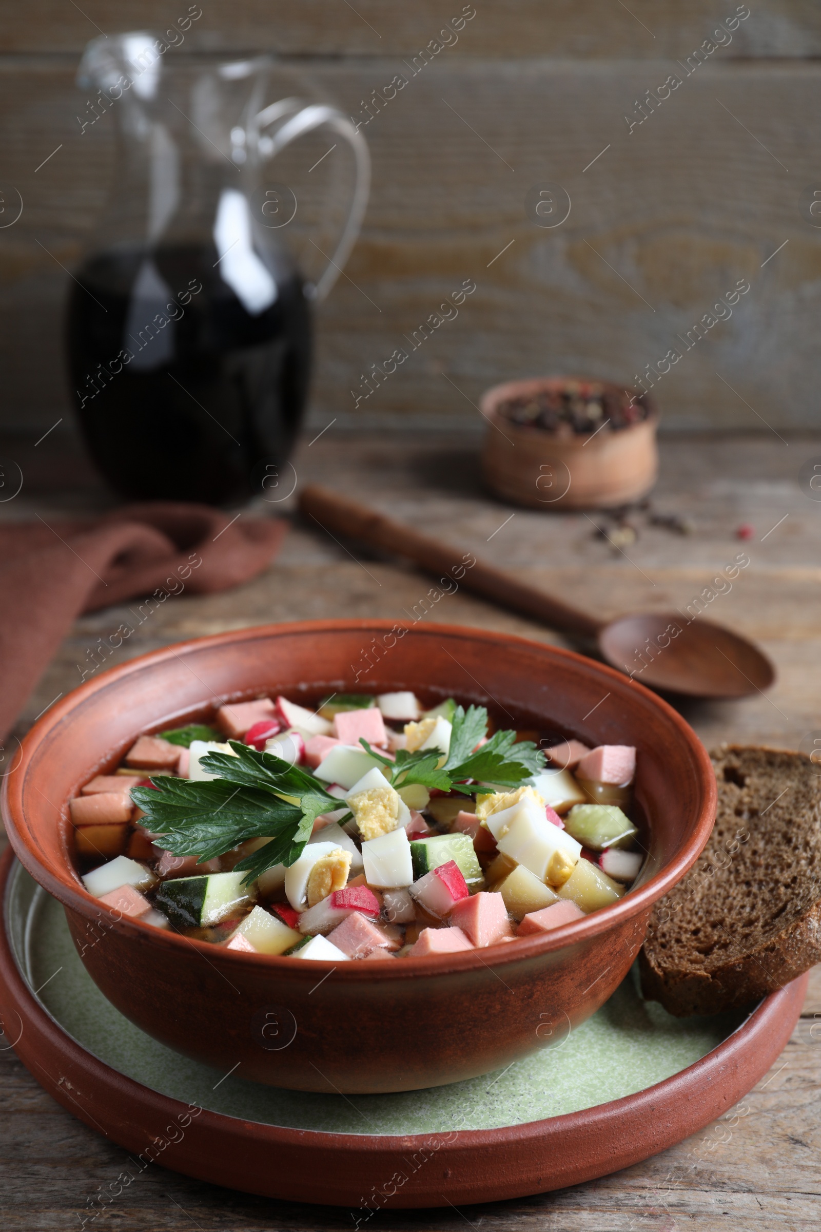 Photo of Delicious cold okroshka with kvass served on wooden table. Traditional Russian summer soup