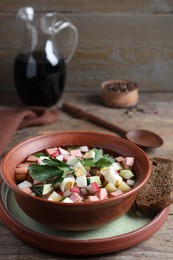 Delicious cold okroshka with kvass served on wooden table. Traditional Russian summer soup