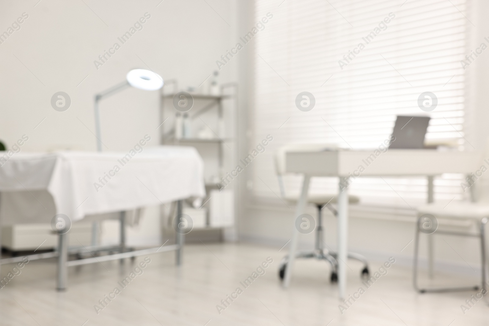 Photo of Blurred view of dermatologist's office with examination table