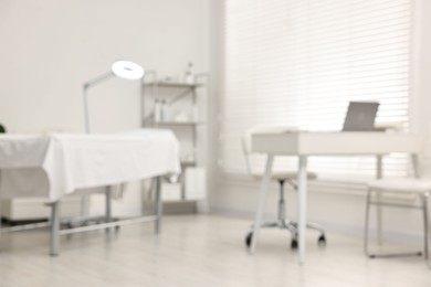 Photo of Blurred view of dermatologist's office with examination table