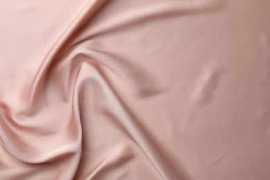 Photo of Crumpled pink silk fabric as background, top view