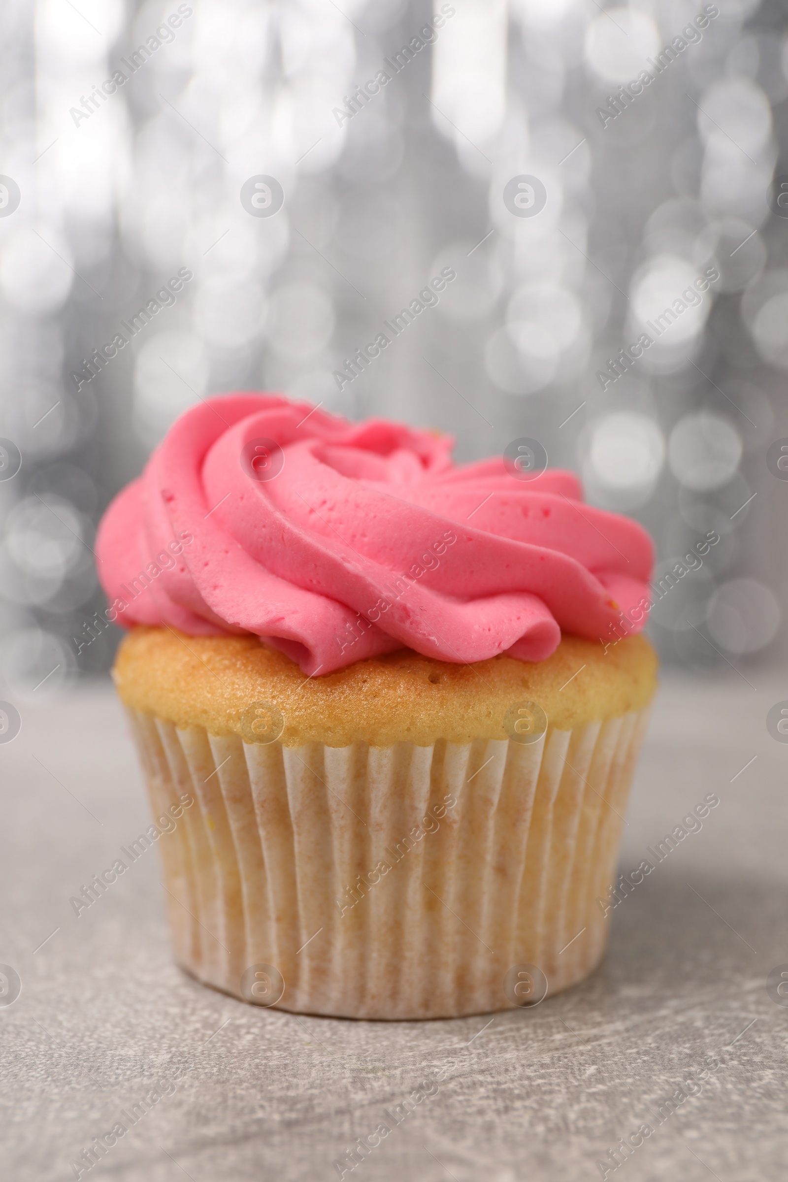 Photo of Delicious cupcake with bright cream on grey table, closeup