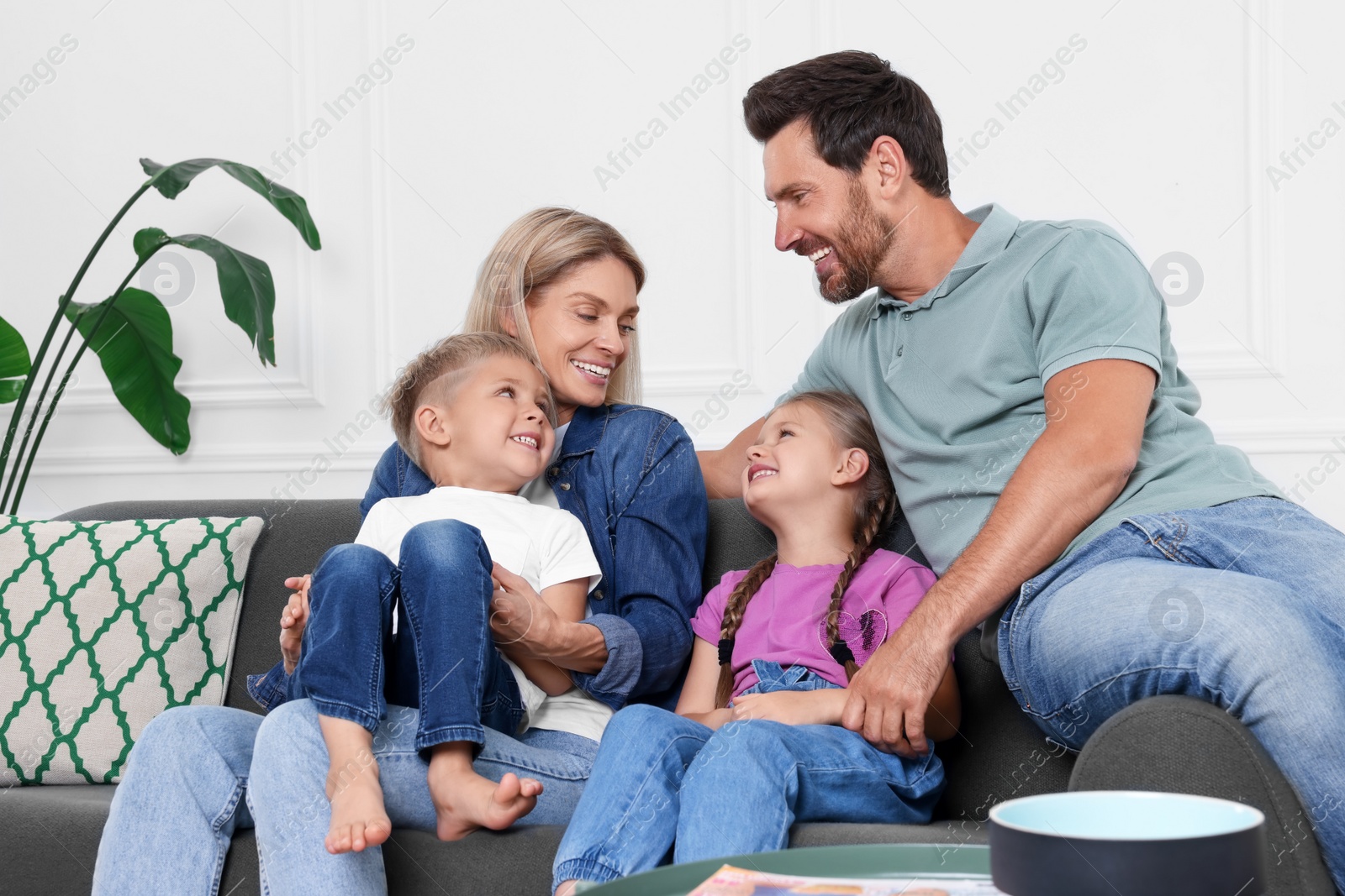 Photo of Happy family having fun together on sofa at home