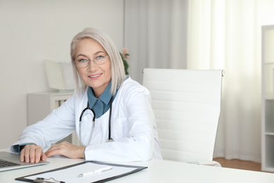 Photo of Portrait of mature female doctor in white coat at workplace