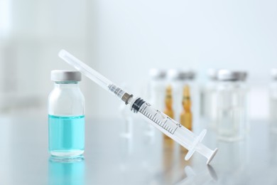 Syringe with vial of medicine on table