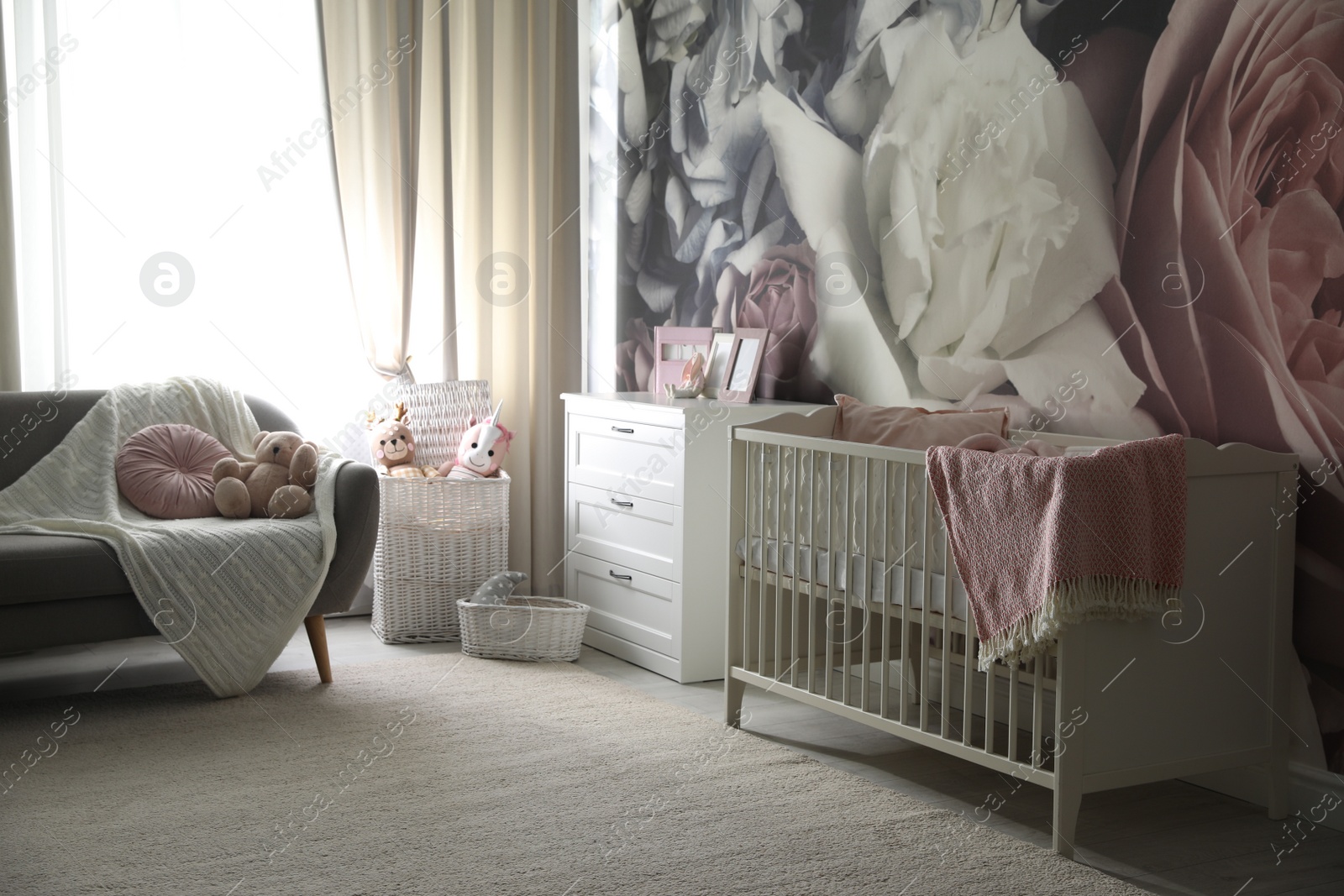 Photo of Baby room interior with stylish crib and floral wallpaper