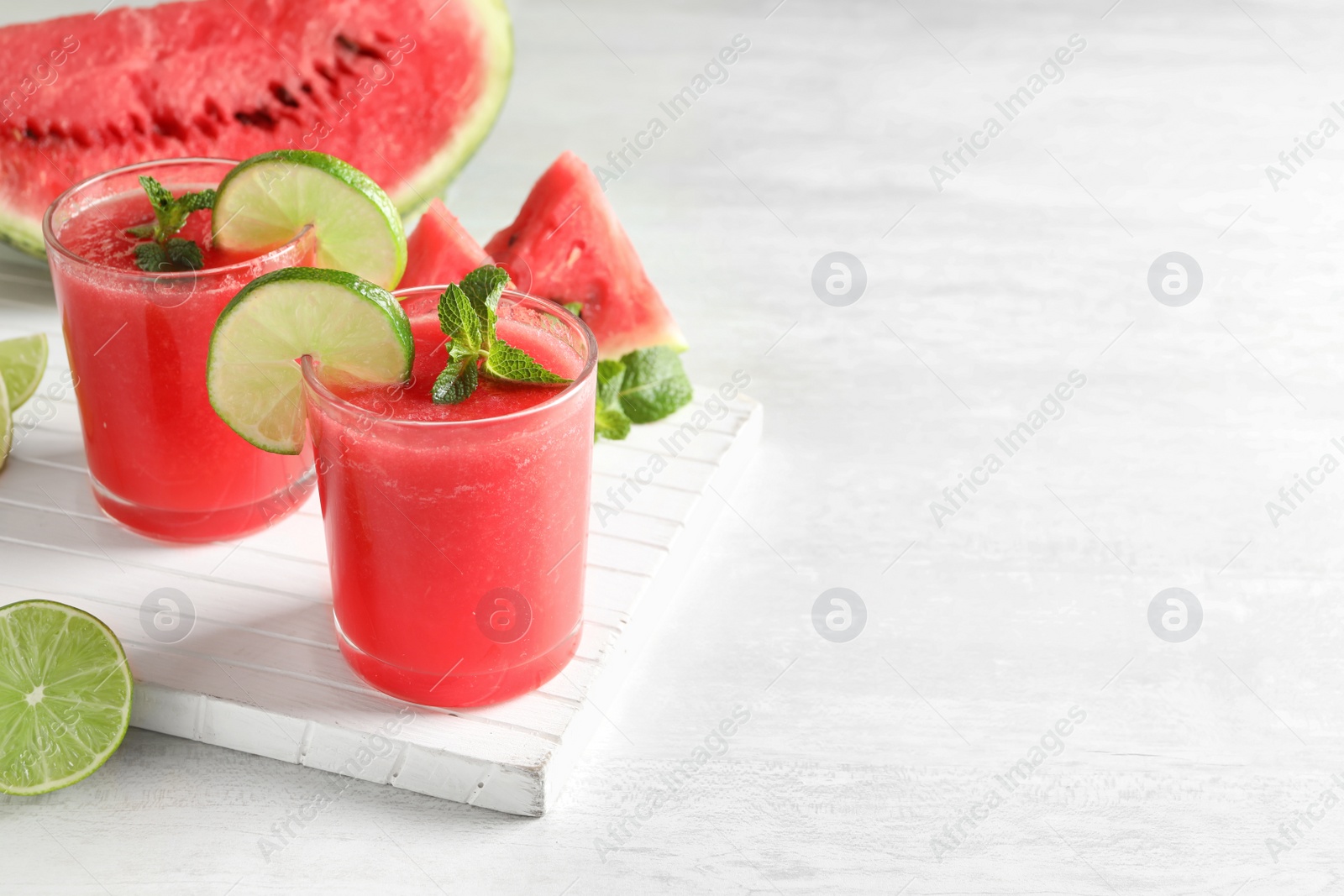 Photo of Tasty summer watermelon drink in glasses and space for text on table