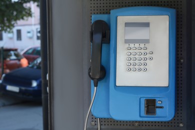 Photo of Pay phone on city street, closeup. Space for text