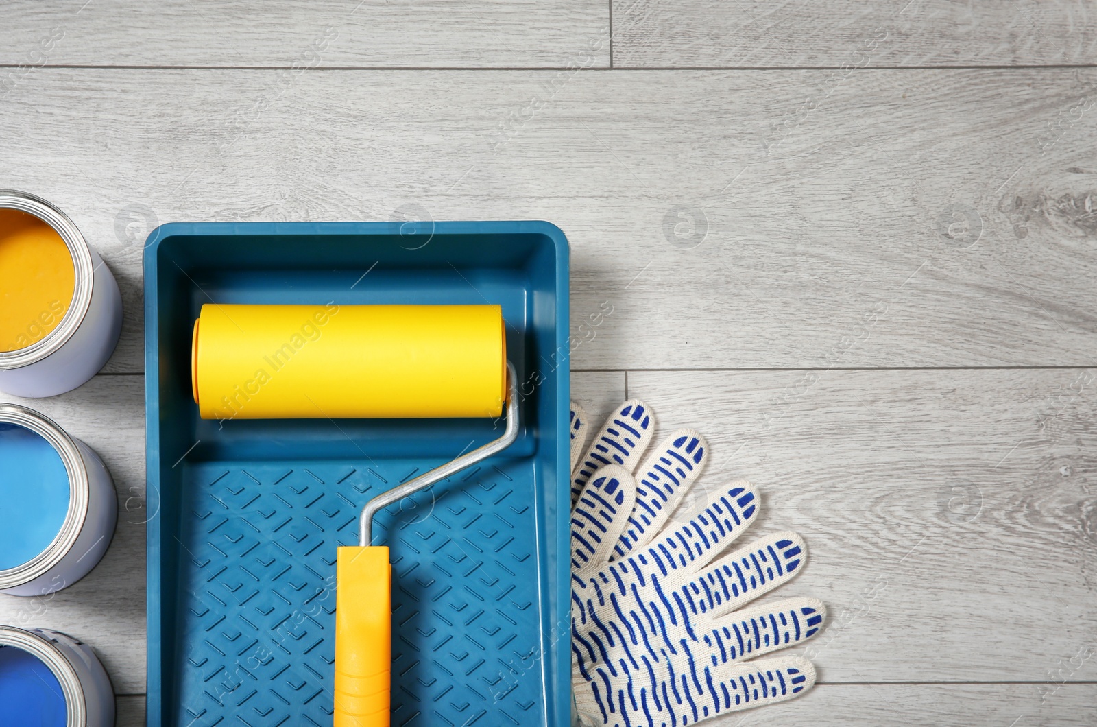 Photo of Flat lay composition with cans of paint and decorator tools on wooden background