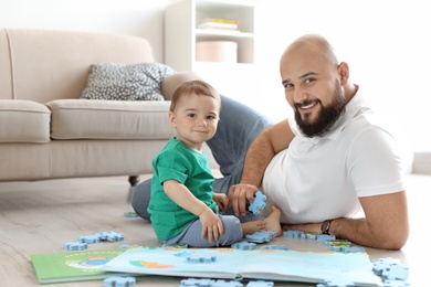 Photo of Dad and his little son playing together at home