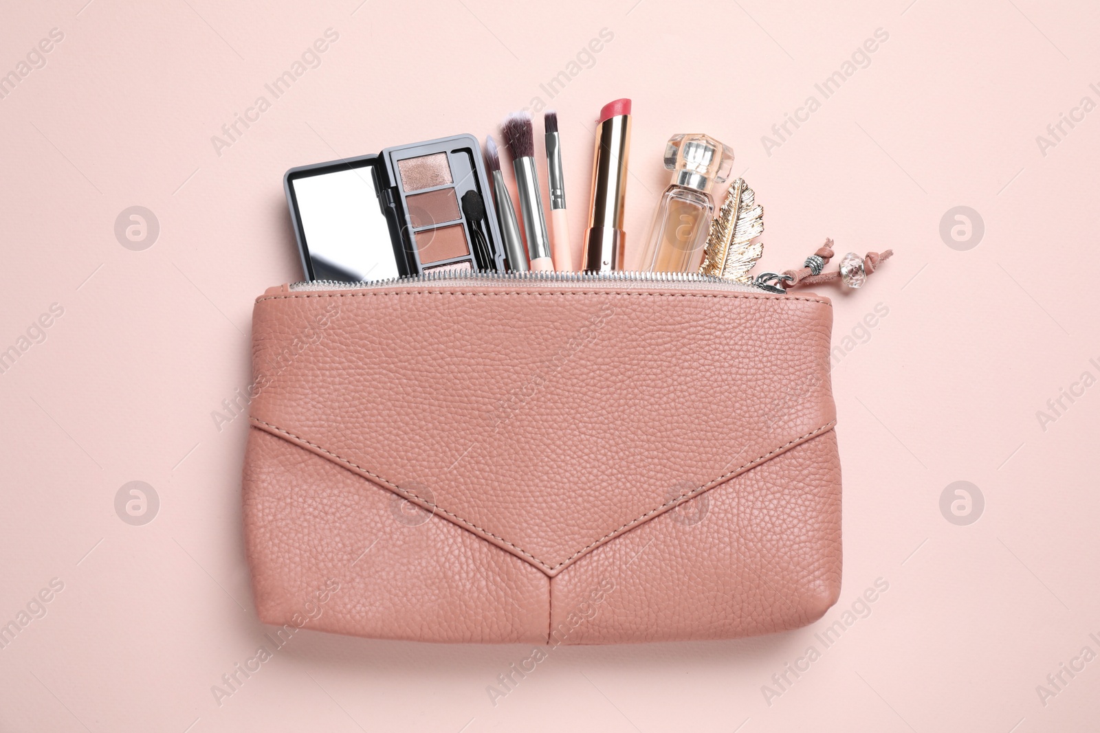 Photo of Makeup products with cosmetic bag on pink background