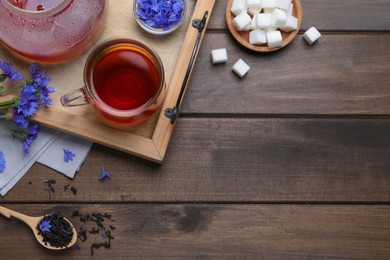 Photo of Composition with tea and cornflowers on wooden table, flat lay. Space for text