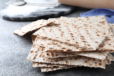 Photo of Stack of traditional matzos on grey table, closeup