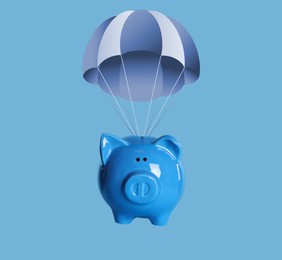 Image of Cute piggy bank with parachute flying on blue background