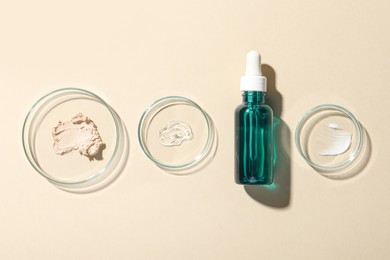 Bottle of cosmetic serum and petri dishes with samples on beige background, flat lay