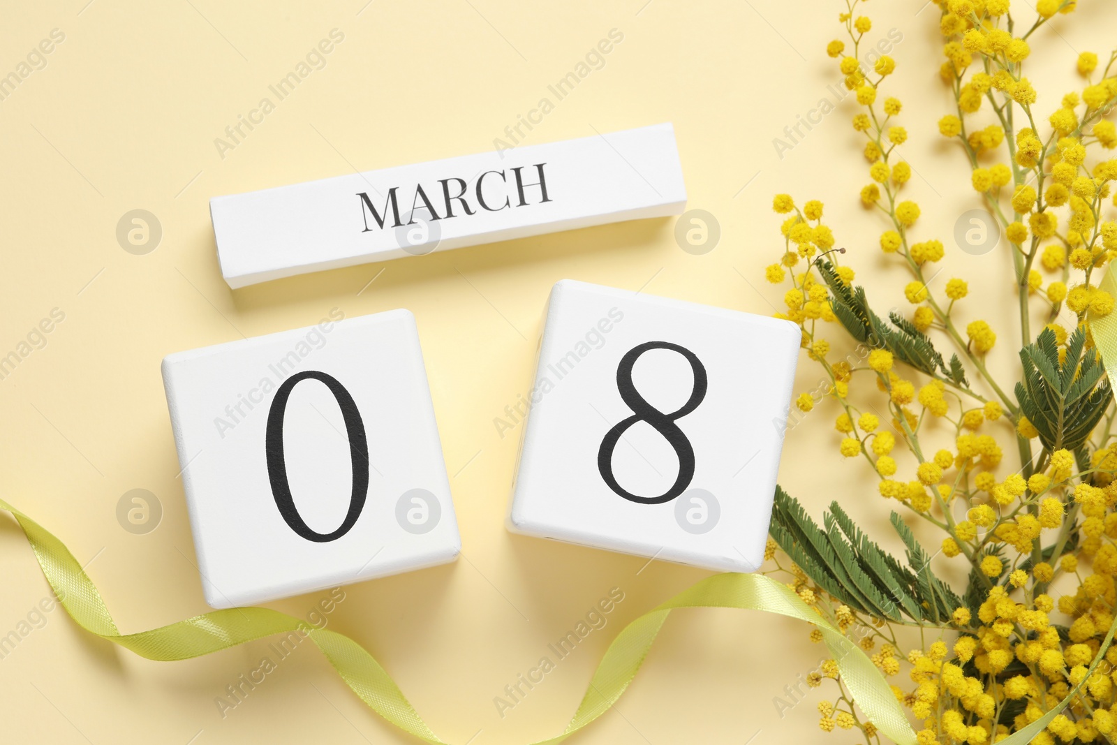 Photo of International Women's day - 8th of March. Wooden block calendar and beautiful flowers on beige background, flat lay