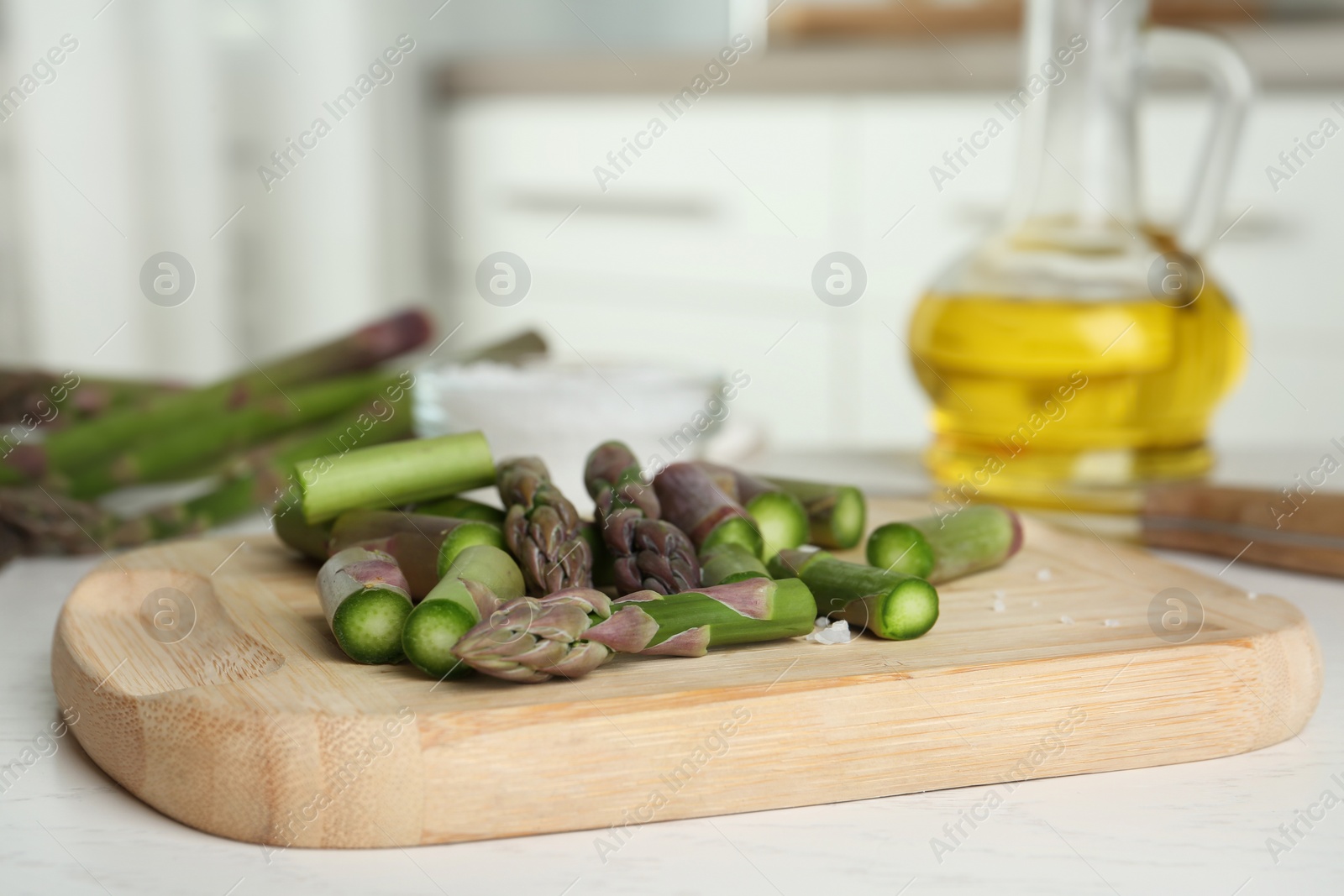 Photo of Fresh raw asparagus on white table, closeup