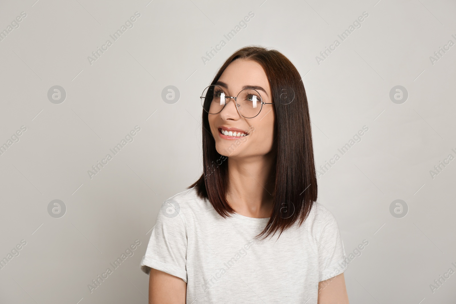 Photo of Portrait of pretty young woman with gorgeous chestnut hair and charming smile on light background