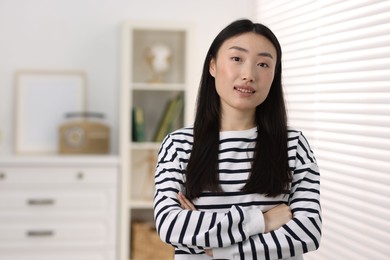 Portrait of smiling businesswoman with crossed arms in office